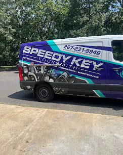 Speedy Key Locksmith van parked on a driveway, showing service graphics and phone number 267-231-9946.